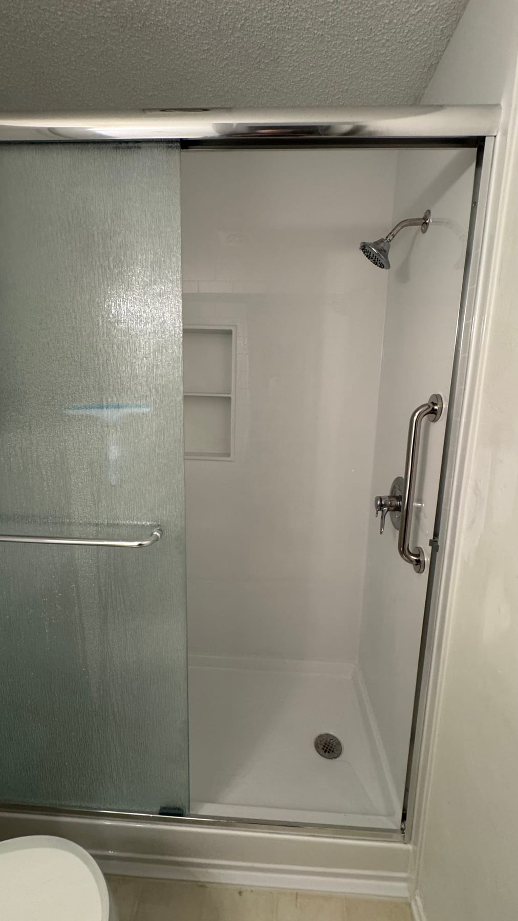 White walk-in shower with safety grab bars
