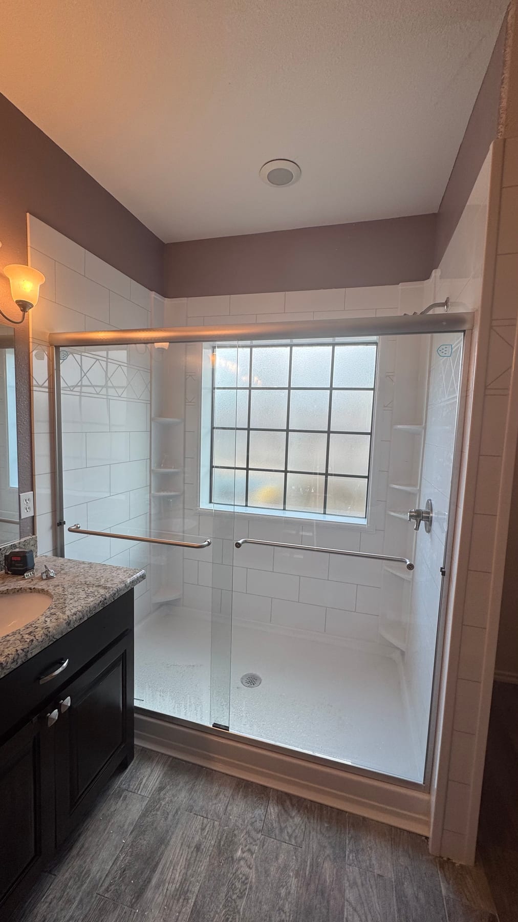 Bright walk-in shower with window and built-in corner shelves