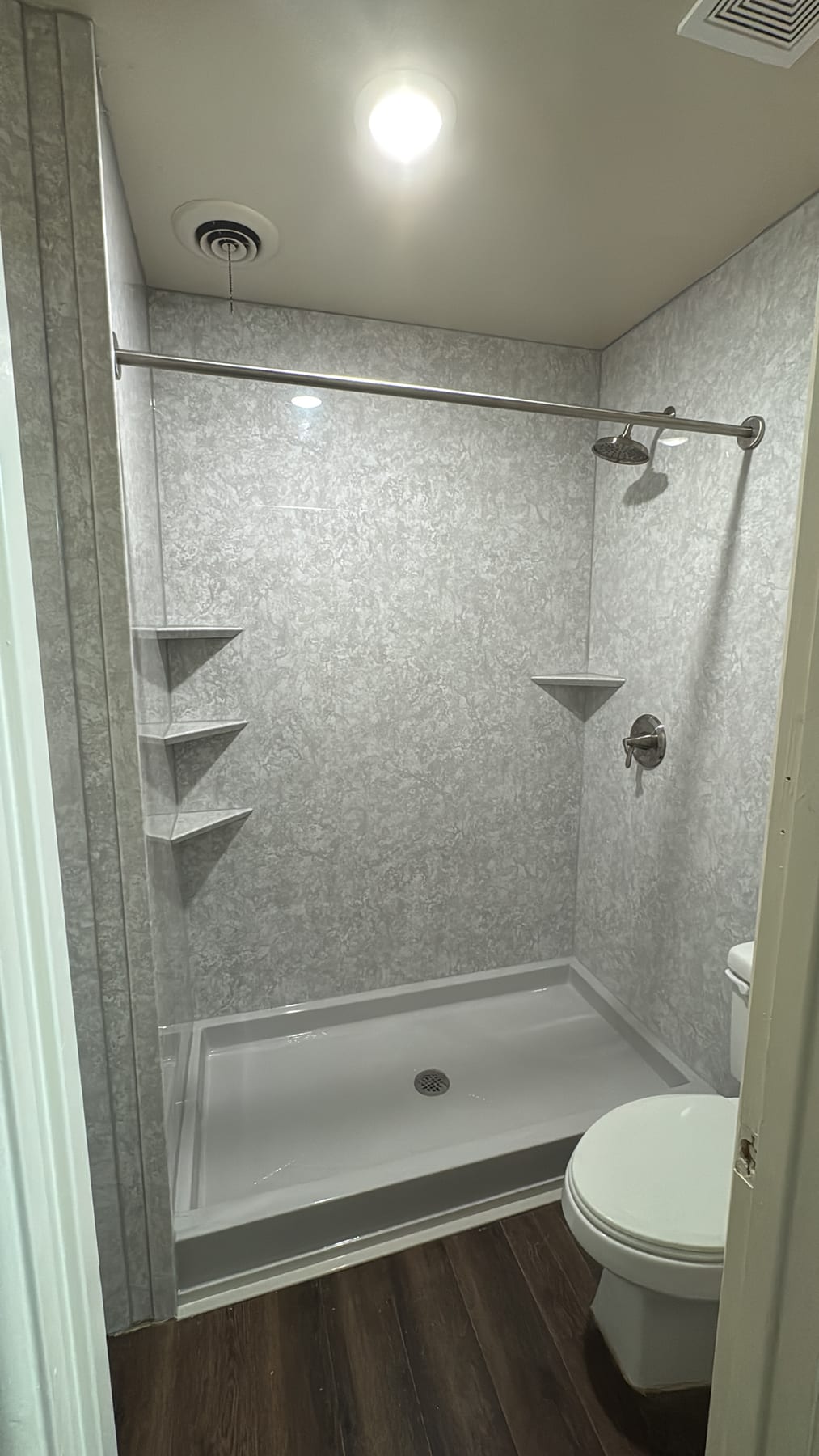 Gray stone-look walk-in shower with built-in corner shelves