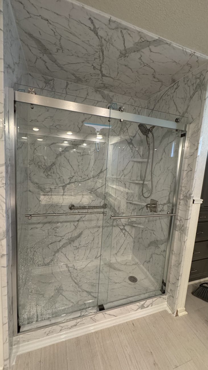 Marble-look shower with sliding glass doors